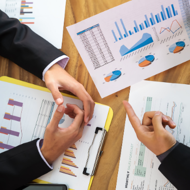 People discussing over graphs on a table