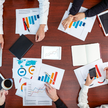 Employees working with graphs sheets on a table