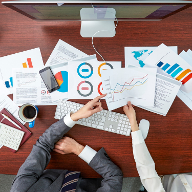 Data analysts looking at sheets of graphs