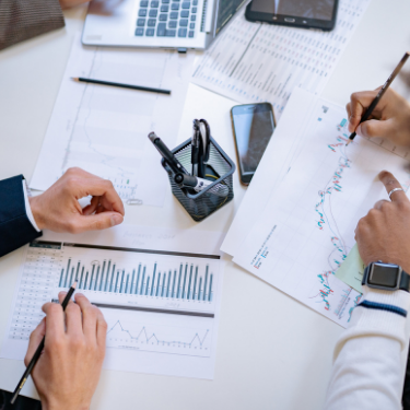 Two professionals working with printed graphs